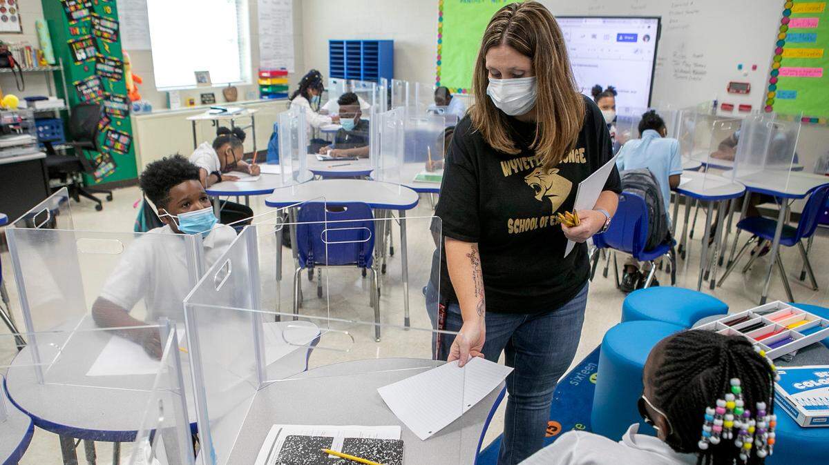 In her sixth-grade classroom at Wyvetter Younge School of Excellence in East St. Louis, teacher Cynthia Roller hands out paper for a classroom assignment.