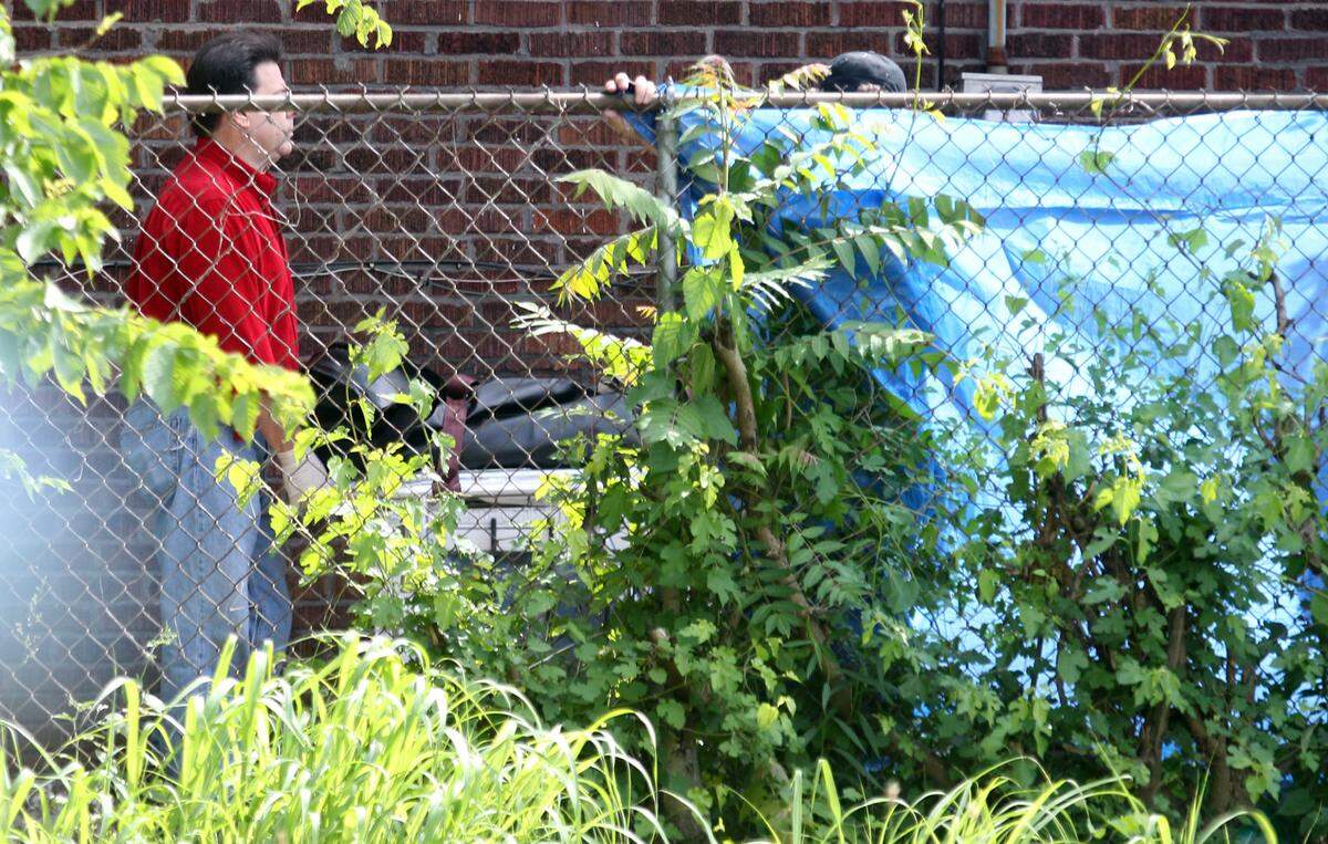 One of the two bodies is moved to a waiting hearse. Police responded Friday afternoon to a house a 640 N. 23rd St., where a husband and wife were found dead with two small children inside in 2012.