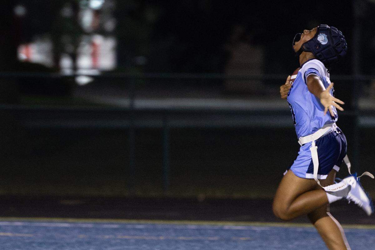 Belleville East sophomore Peyton Griffith celebrates as she crosses into the end zone to score a 98-yard pick-six during the inaugural girls flag football game against Belleville West at Charles Woodford Field on Aug. 28, 2024.