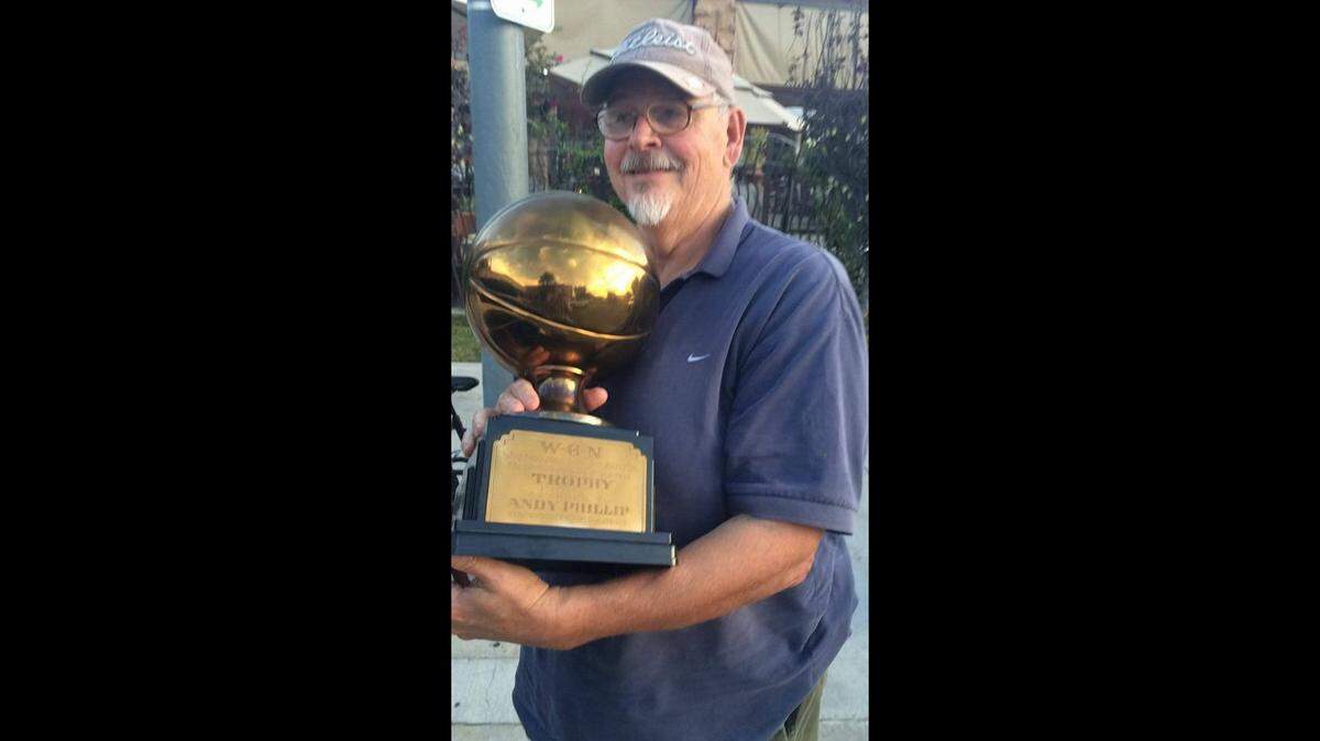 Dan Manoyan, who wrote the 2007 book “Men of Granite,” holds Andy Phillip’s 1943 Big Ten basketball MVP trophy. It’s now in the University of Illinois’ State Farm Arena display case.