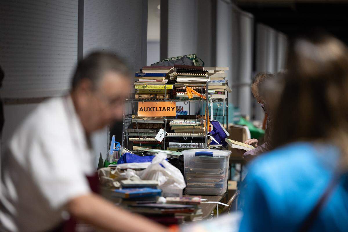 Members of the Belleville Memorial Hospital Auxiliary help stow books as customers continue their shopping during the 2026 book bazaar at the Belle-Clair Fairgrounds.