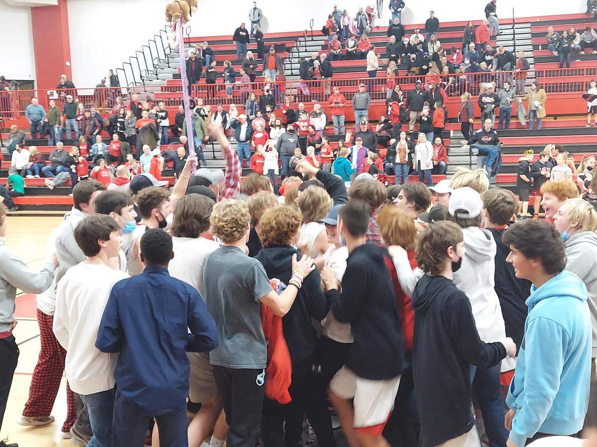Highland players and students celebrate after the Bulldogs knocked off Triad for a 55-54 Mississippi Valley Conference win Friday, Dec. 17, at Highland High School.