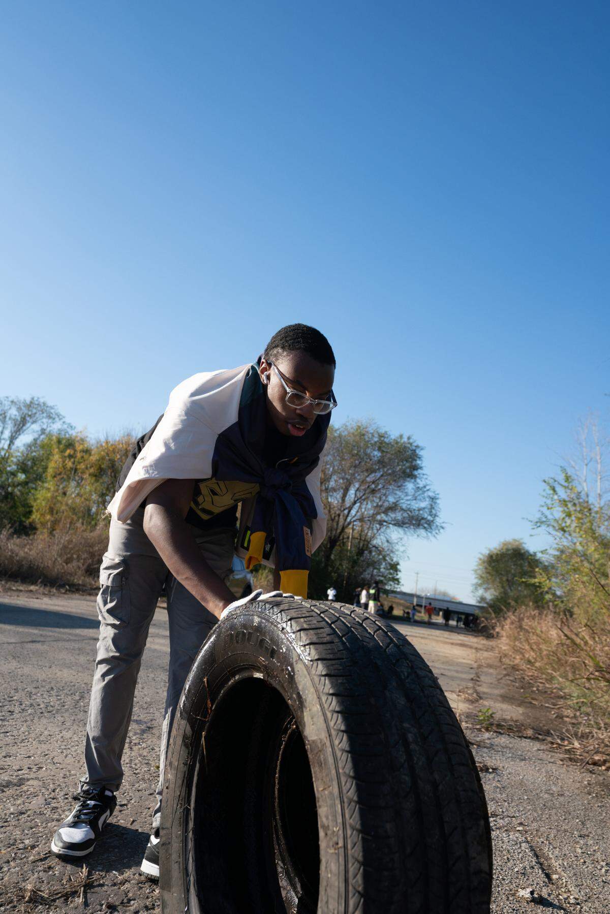 SIUE student Phillip Russell rolls tires to a disposal site during a cleanup in East St. Louis on Nov. 15, 2024.