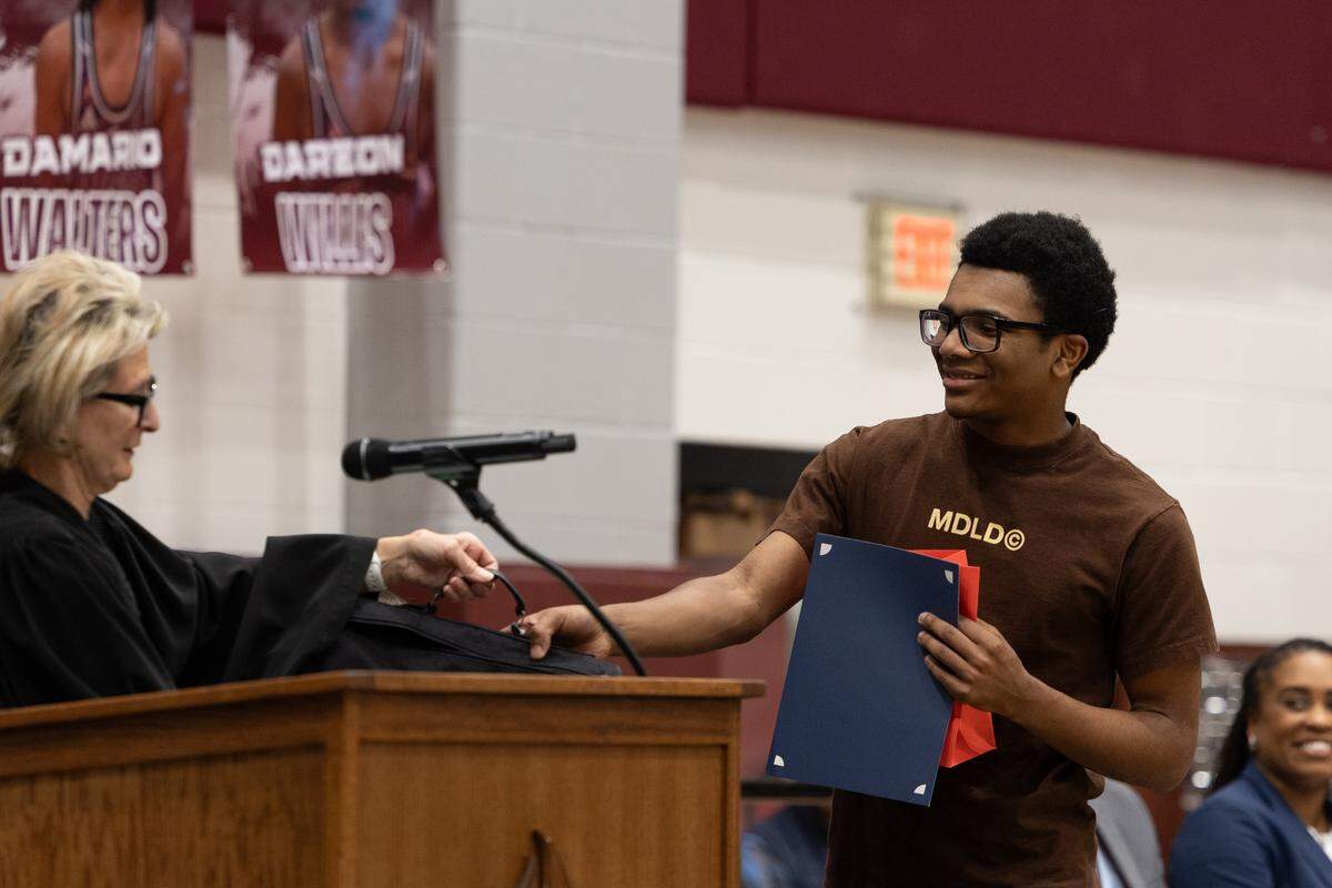 Belleville West student Alijah “AJ” Burrell accepts a “Last Paragraph” award at Friday’s naturalization ceremony.