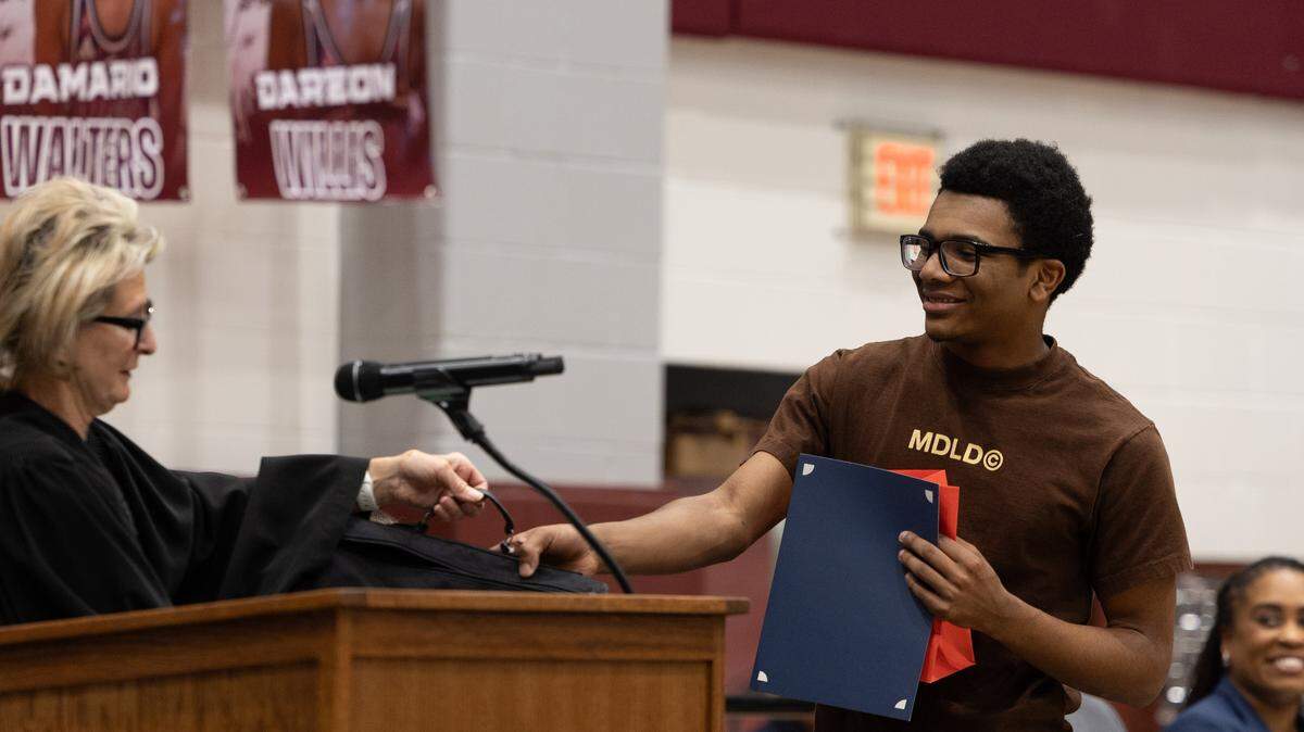Belleville West student Alijah “AJ” Burrell accepts a “Last Paragraph” award at Friday’s naturalization ceremony.