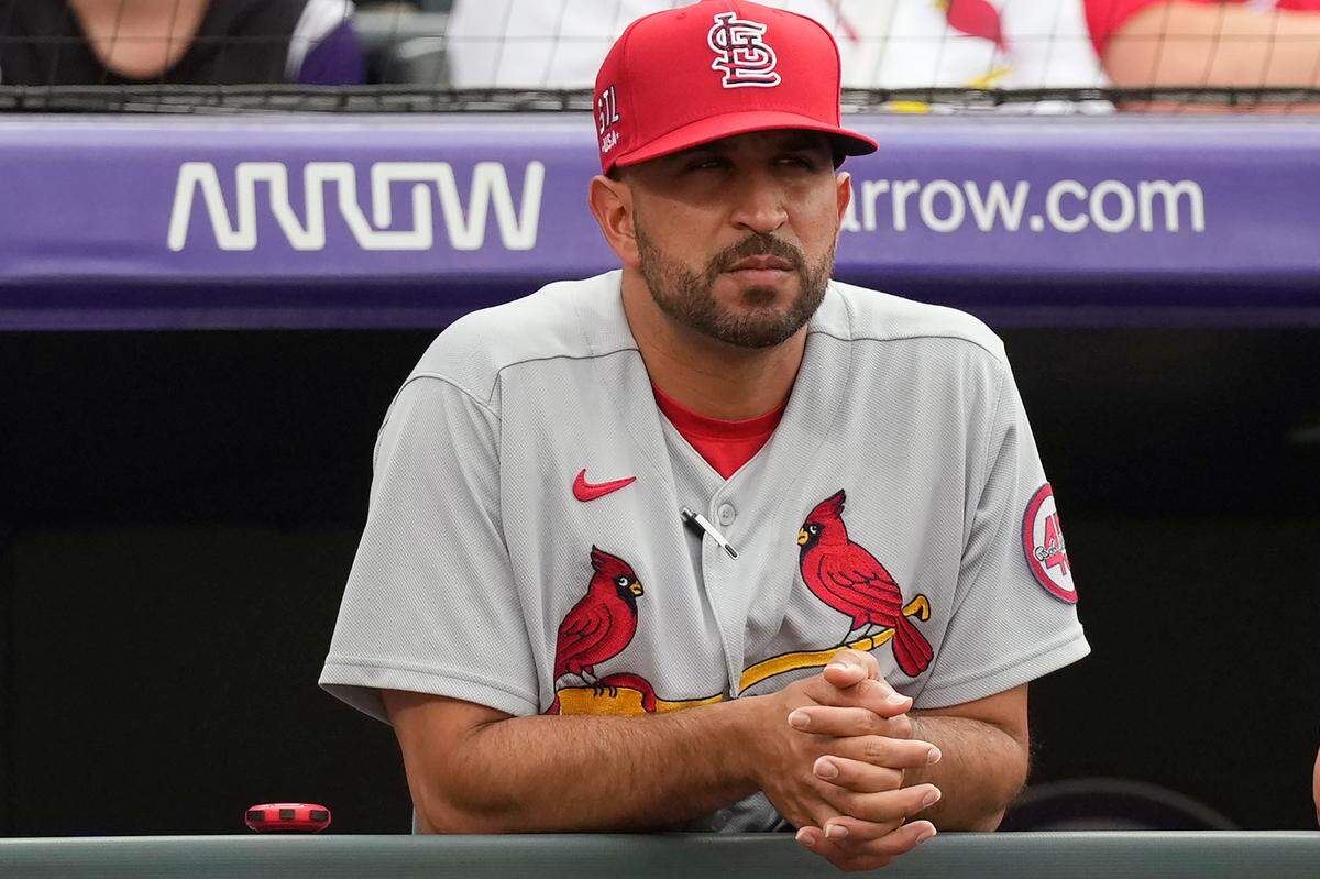 St. Louis Cardinals bench coach Oliver Marmol watches from the dugout in the first inning of a road game against the Colorado Rockies last season. Overall, Marmol's first week of his first season as manager of the Cardinals didn’t go exactly as he had imagined. In that time, his team played two games with him in the dugout, played two more games with him sick at home with the flu, and had two games rained out on top of a scheduled off day.