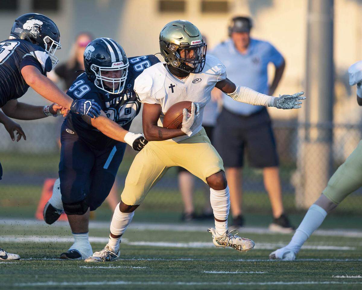 Althoff’s Malik Nave carries the ball against Mater Dei on Friday night. Nave and the Crusaders ultimately prevailed 13-7.