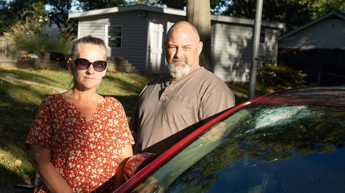 Brandi Matheis and Paul Earnest of O'Fallon stand next to the windshield of Earnest’s car, which was damaged when someone threw a rock as they were traveling about 60 mph on Interstate 255 in Cahokia Heights on Monday.
