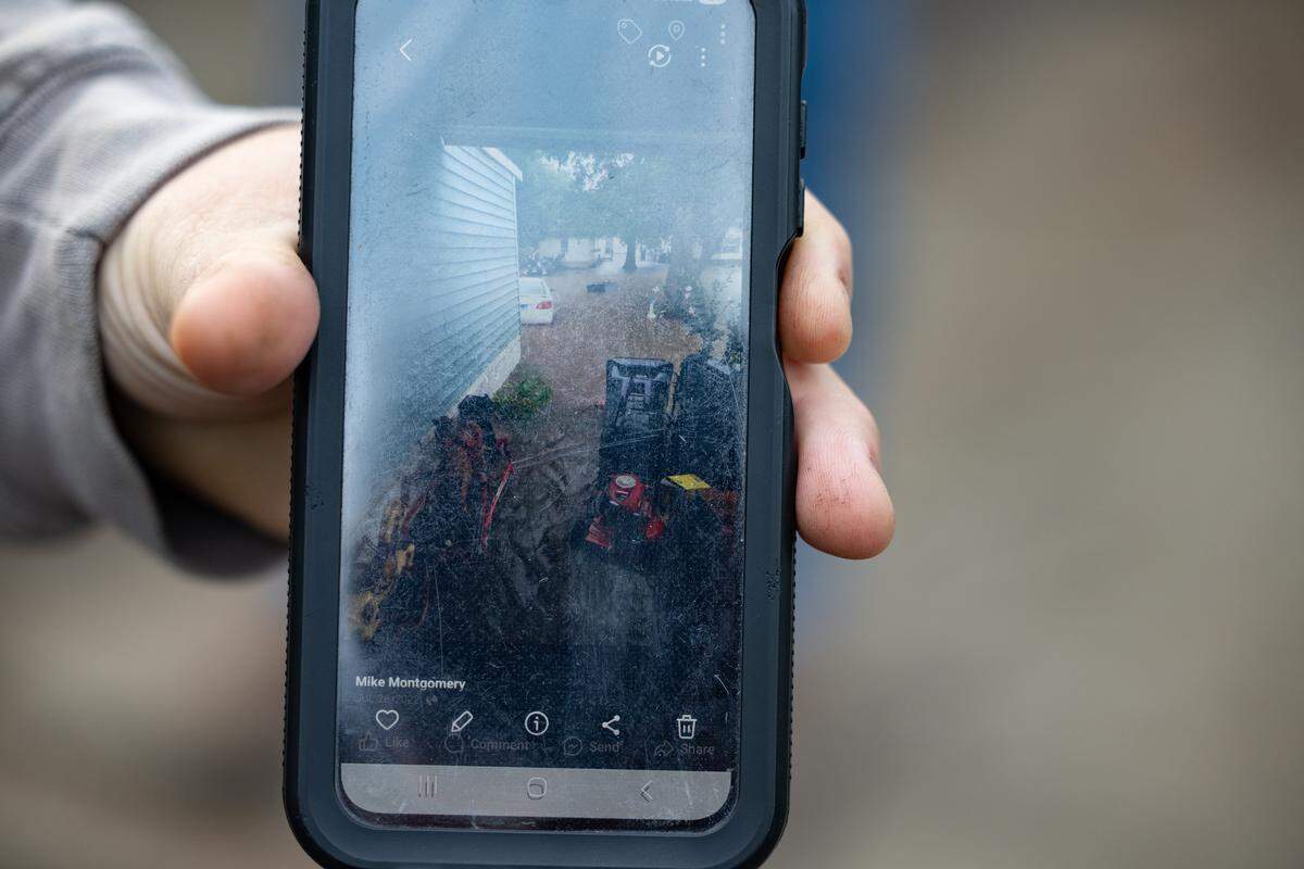 Greenmount Station resident Michael Montgomery shows a photograph on his phone of flooding that occurred in the mobile home park during a heavy rainfall earlier this year.