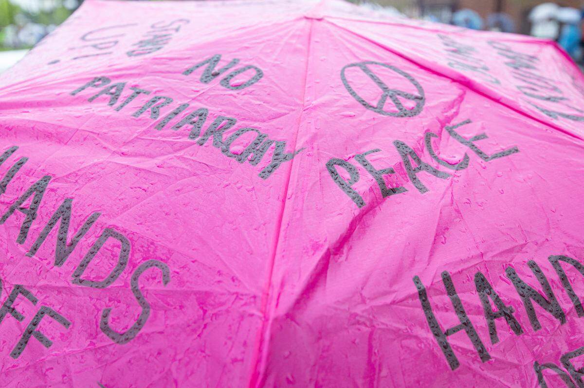With thunderstorms affecting the protest, many demonstrators chose to write slogans on their umbrellas in lieu of signs.