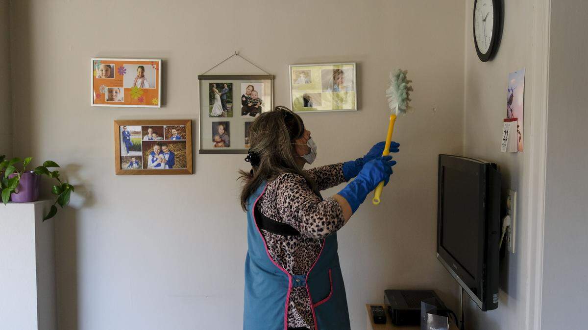 A woman dusting a home.