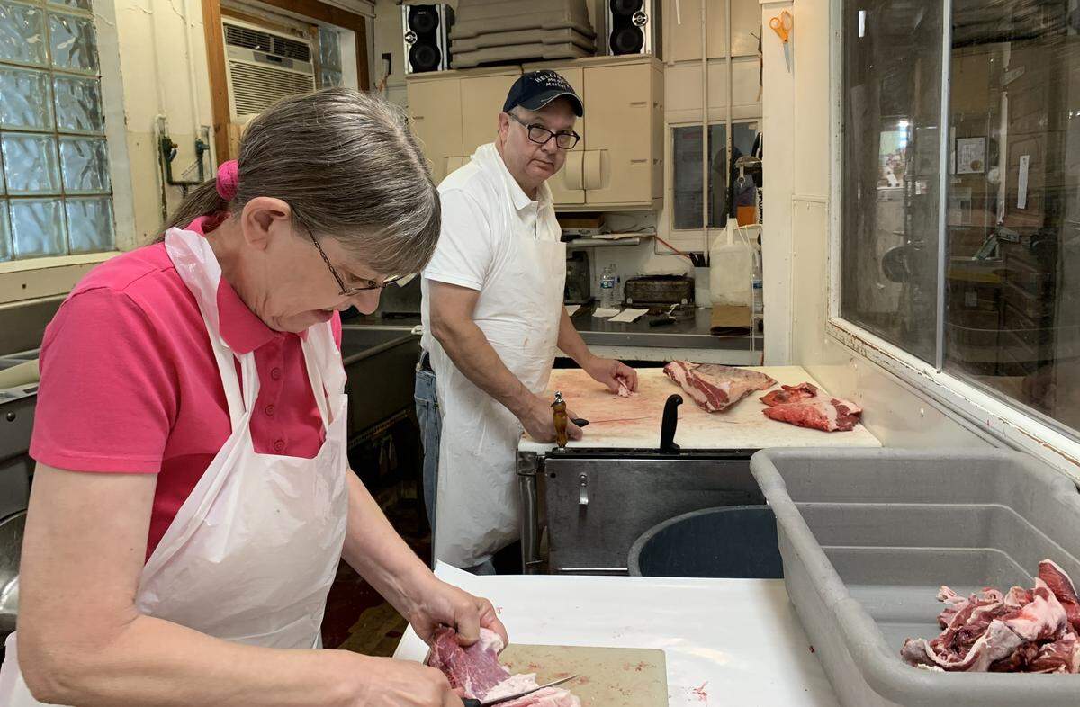 Geralyn Hodapp, left, and Steve Hellige cut meat at Hellige’s Super Market & Lockers in Breese.