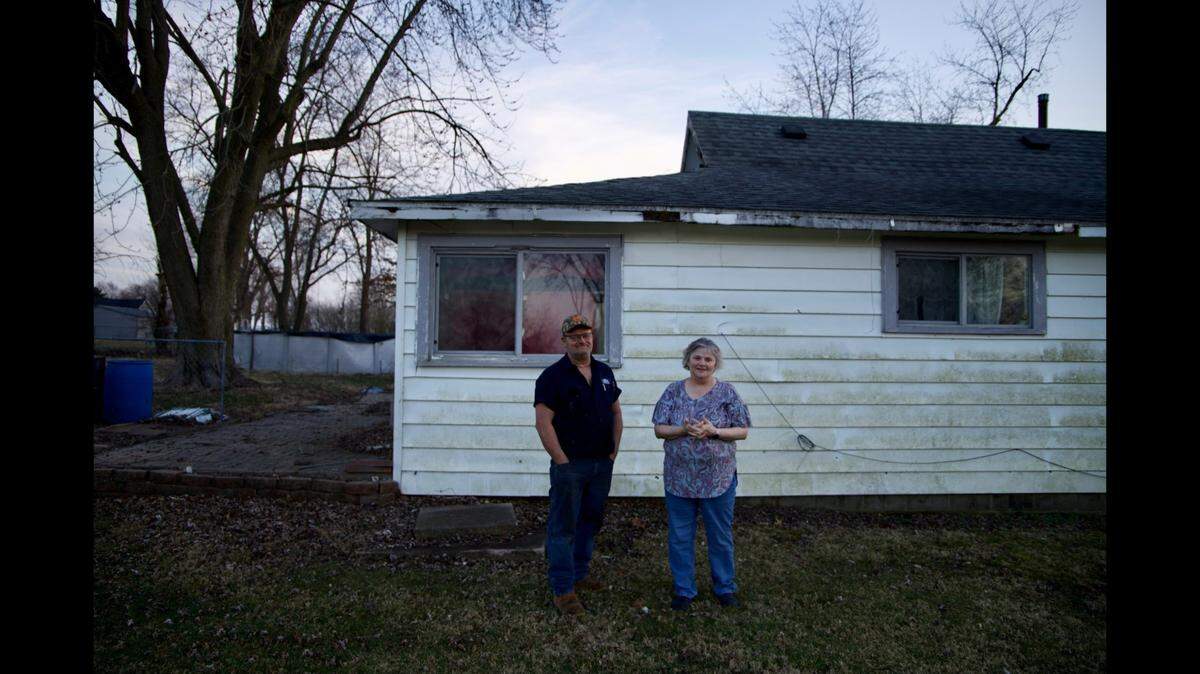 Scott and Berdeena Leturno stand outside their old home on North Vine Street in Dieterich, Illinois, where they lived and raised their four children for nearly 20 years. Feb. 27, 2024