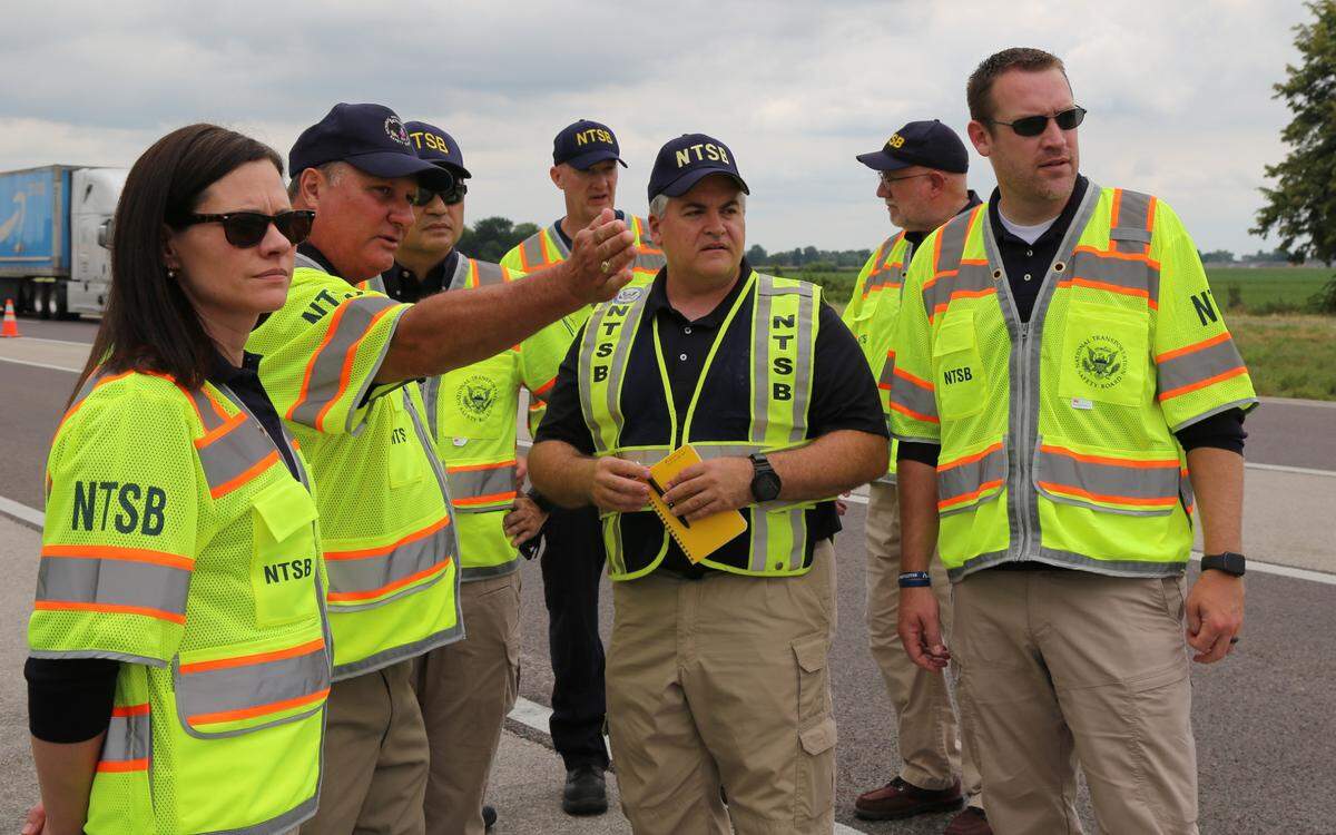 In this July 13, 2023 photo, a National Transportation Safety Board team, including investigator-in-charge Steve Prouty (center), stands at the site of the July 12 crash on I-70 near Highland, Illinois.