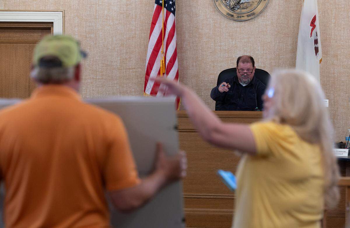 Granite City Mayor Mike Parkinson, center, responds to Charles and Mary McCoy during a City Council meeting on May 5. They were speaking out against data center development.