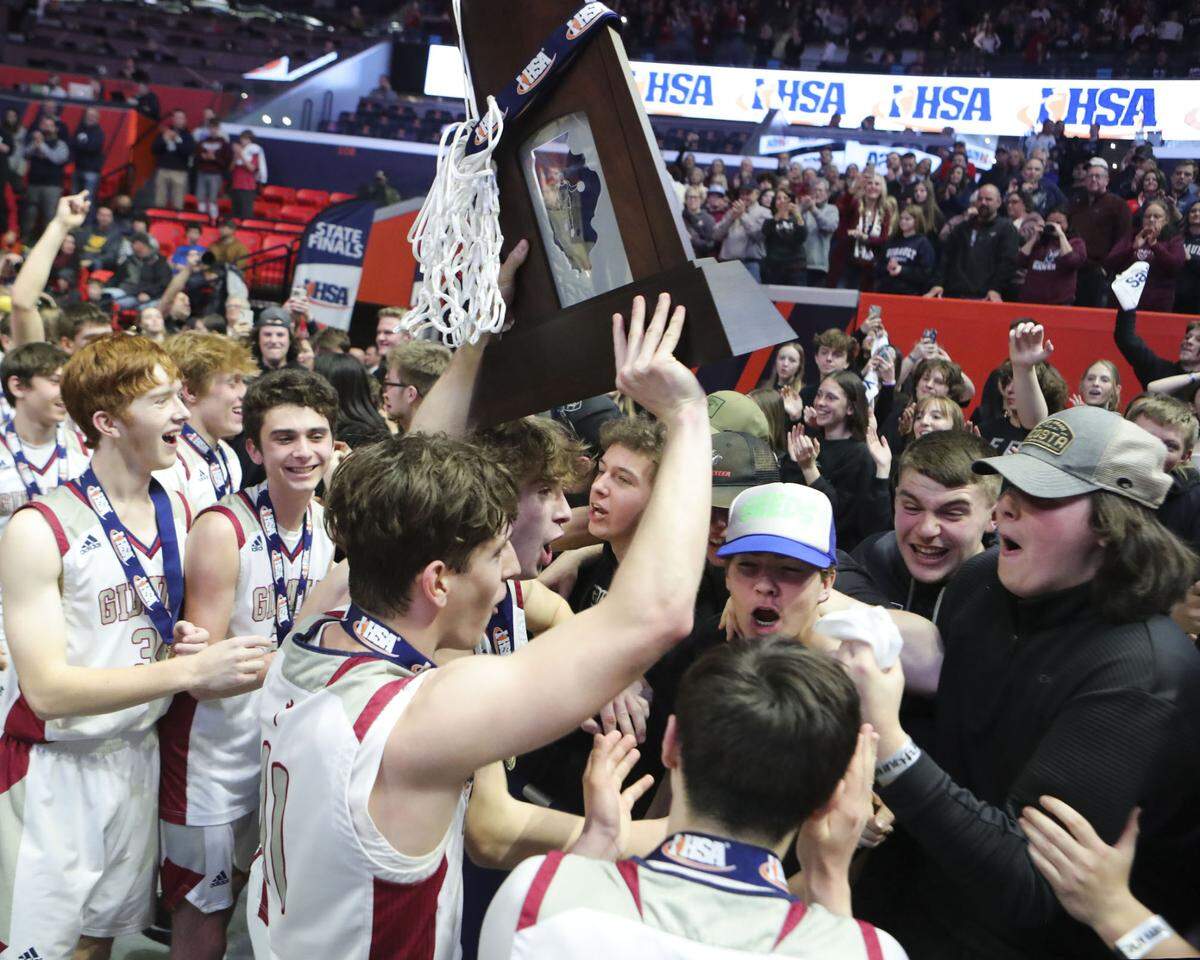 Gibault’s Kameron Hanvey takes the championship trophy to the fans after Saturday’s IHSA Class 1A state championship game against Scales Mounds at the State Farm Center on the campus of University of Illinois. Gibault ultimately prevailed 65-45 to claim the state title.