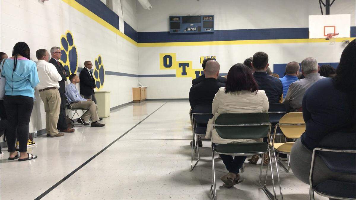 JaRon Dent, seated at left, listens as his supporters speak to O’Fallon Township High School District 203’s school board at its April 23, 2019, meeting when a reprimand for Dent was on the agenda. Dent is a special education and driving instruction teacher and coach.