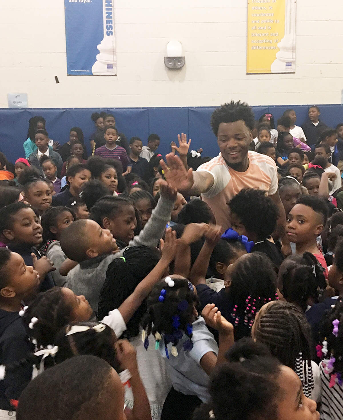 Marcell Cannon, aka Luh Cell, stands surrounded by students from Paul Dunbar Elementary School while recording the video to his latest single, "Honor Roll."