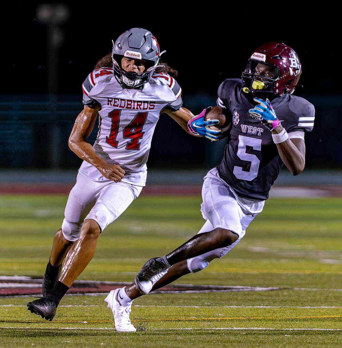 September 20, 2024 - Belleville, IL - De’Shaun Gage (5) runs the ball against Marcus Caruthers during Friday nightsÕs conference matchup between Belleville West and Alton Redbirds on Friday Sept 20, 2024 in Belleville IL. [Photo: Jimmy Simmons]