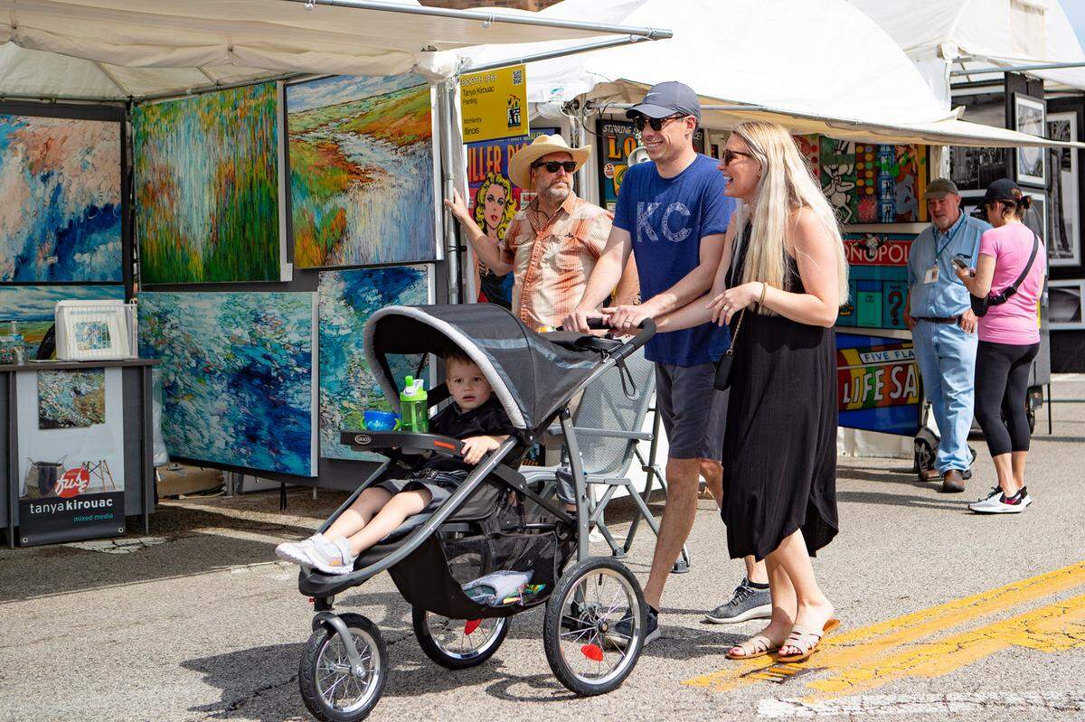 Belleville residents Michael, Paige, and George Rockhold enjoy a Saturday morning stroll while taking in the sights at Art on the Square in downtown Belleville.