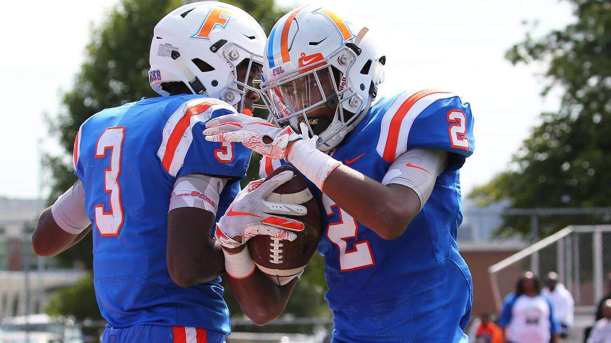Flyers’ Keantez Lewis and Antonio Johnson celebrate after a touchdown during their win over Belleville West last week.