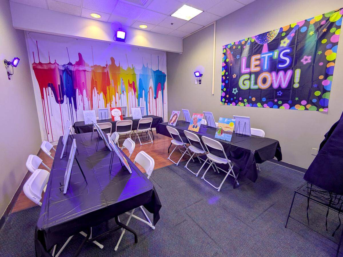 The main painting room at Let's Paint features black lights to make the space glow in the dark.