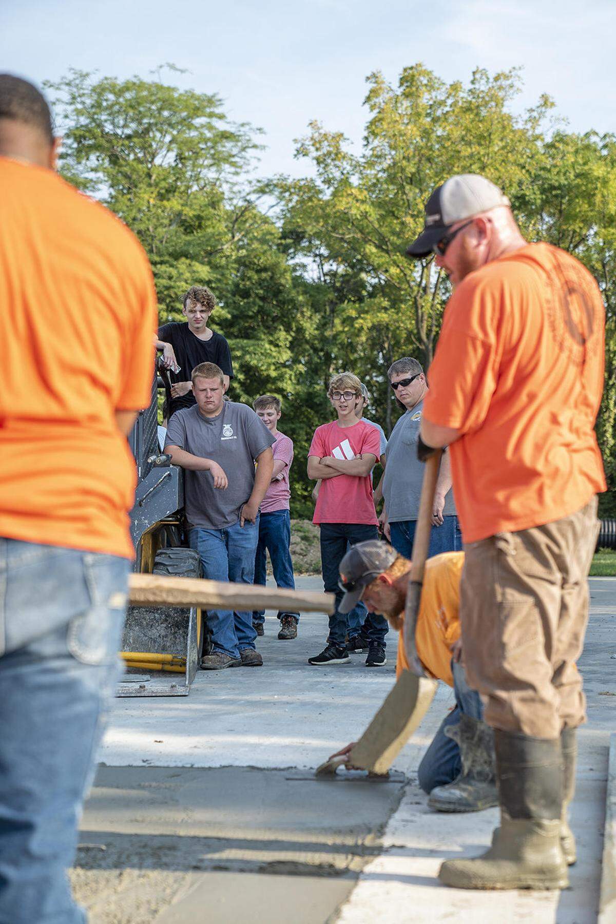 Edwardsville High School juniors watch labor apprentices level off concrete. The students will have an opportunity to pour concrete as they progress through their two-year program.