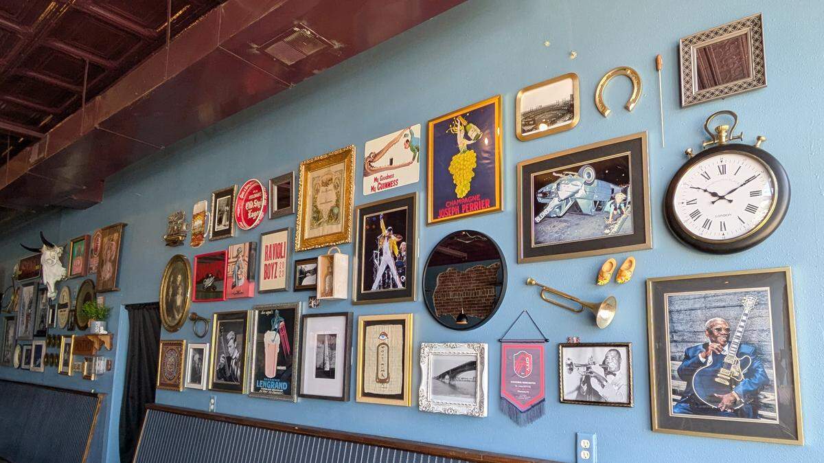 The wall collage at The Upright Pub & Music Parlor reflects the owners’ interests, including music, travel, family and sports.