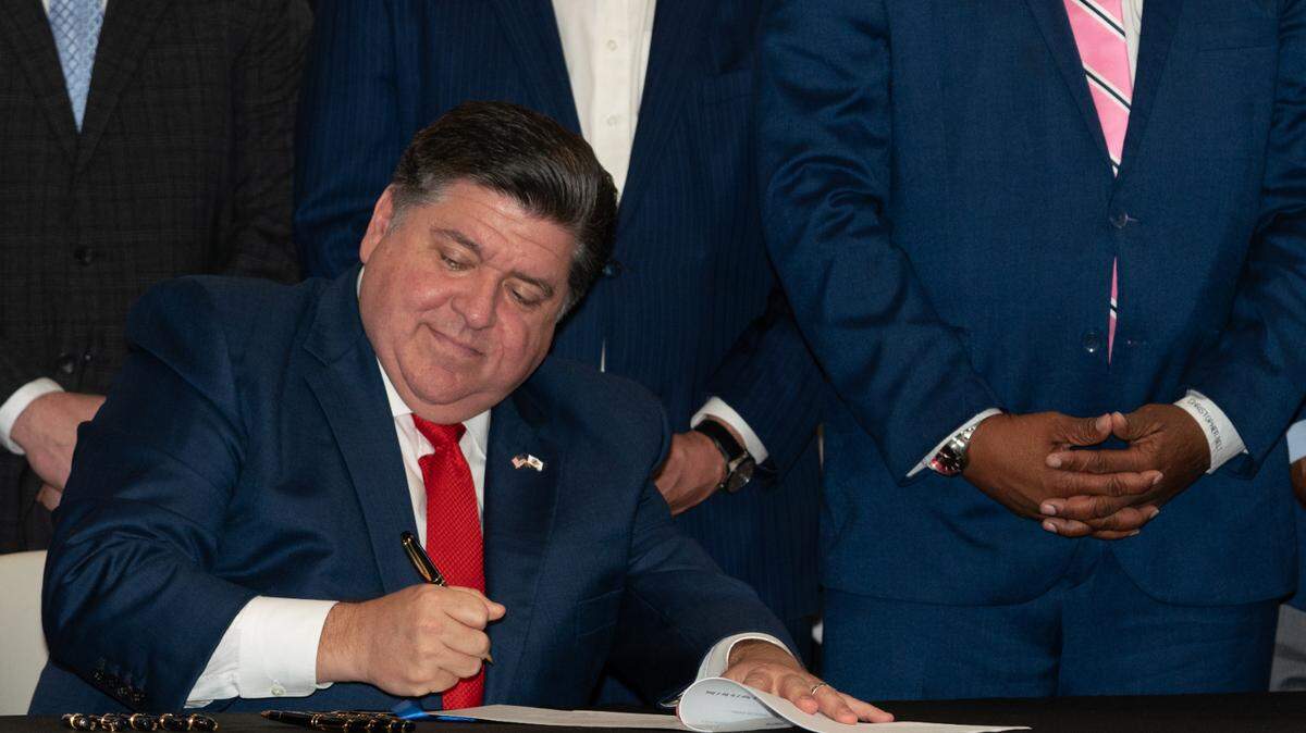Gov. J.B. Pfitzker signed a bill granting roughly $20 million to combat food deserts in rural, urban and suburban communities as state representatives Jay Hoffman and Chris Belt look on.