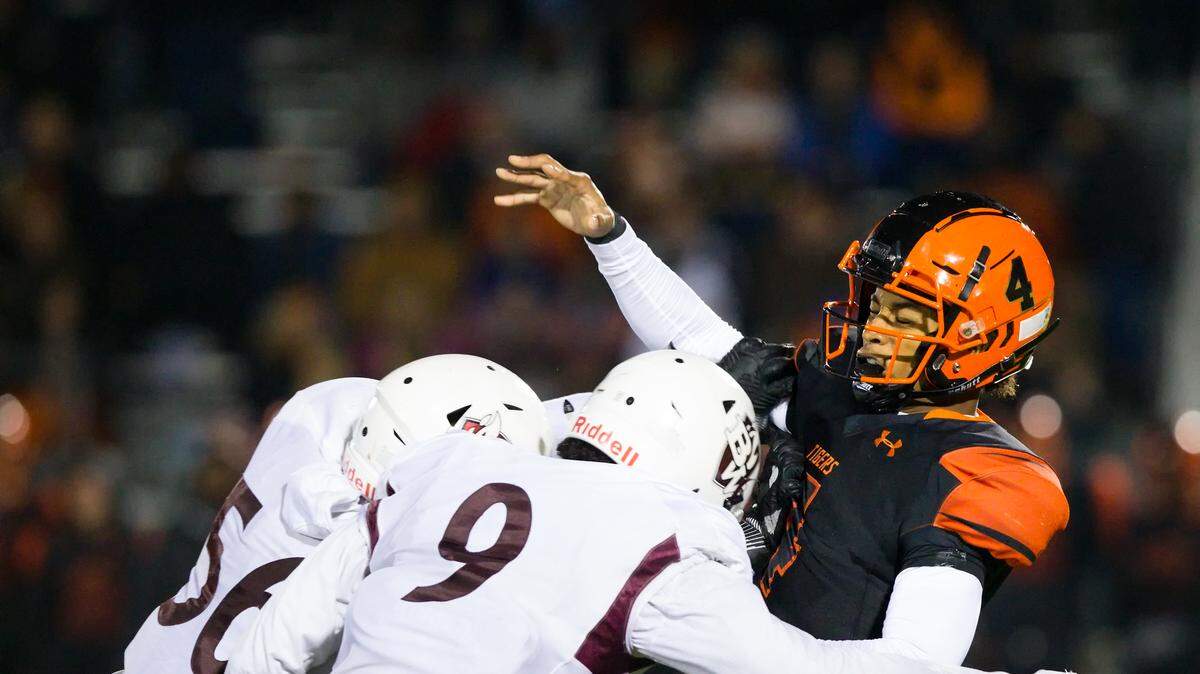 Belleville West Will Shumpert (9) and Belleville West Ka’lon Carraway (56) tackle Edwardsville quarterback Kendall Abdur-Rahman during Friday’s game at Edwardsville High School.