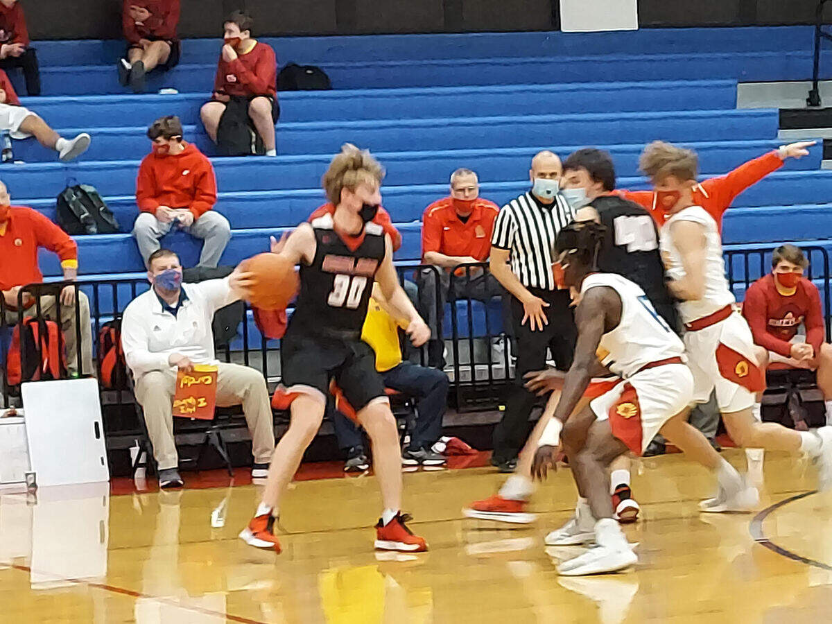 Highland’s Jake Ottensmeier works the ball in the half court against Roxana senior guard Parris White during a game last season. Despite Ottensmeier’s team-high 14 points, the Bulldogs fell to Alton Marquette 34-31 in the semifinals of the Okawville Tournament on Friday, Jan. 21.