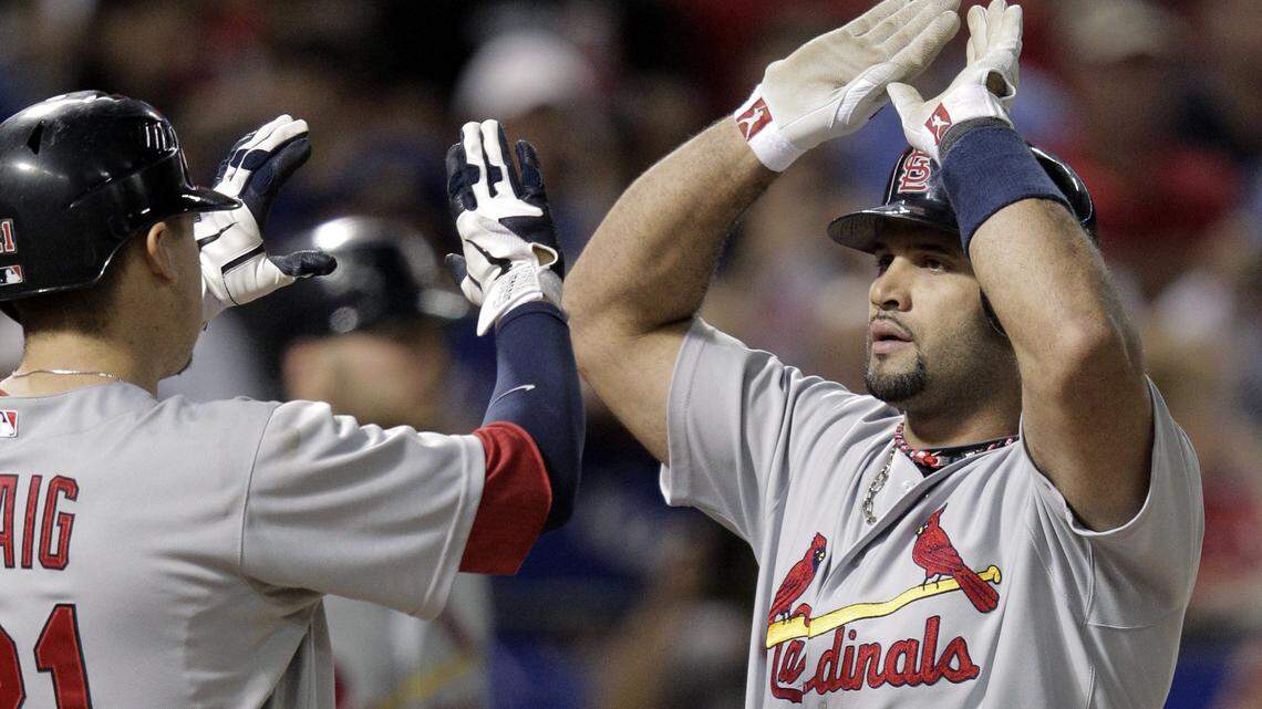 In this AP file photo from Oct. 22, 2011, St. Louis Cardinal Albert Pujols (5) is congratulated by Allen Craig after Pujols hit a two-run home run during the seventh inning of Game 3 of the World Series against the Texas Rangers in Arlington, Texas.