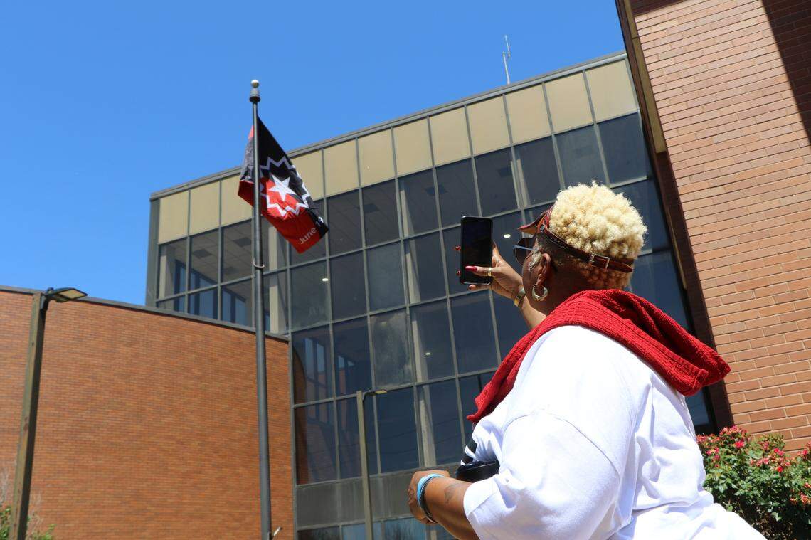 Terra “T-Baby” Jenkins of East St. Louis takes a photo of the Juneteenth flag flying at the East St. Louis municipal building. The city hosted a variety of events Saturday marking the holiday that falls on June 19. Attendees celebrated with a 2.5-mile walk recognizing Ms. Opal Lee, the “Grandmother of Juneteenth.” Lee, 95, is a national activist who promotes the walk annually to represent the two and a half years it took for enforcement of the Emancipation Proclamation to reach Texas. Her efforts resulted in the United States recognizing Juneteenth as a federal holiday. The day’s celebrations also included a flag raising ceremony, a motorcade and the 618 Festival, a celebration with vendors, food and music in East St. Louis.
