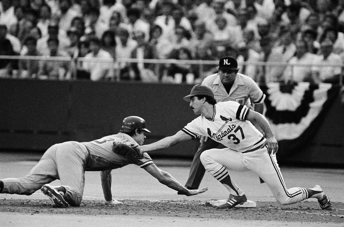 Atlanta Braves Dale Murphy, left, slides safely back to first base past the tag of St. Louis Cardinals Keith Hernandez (37) on a pickoff play during third inning action in the first NL Championship game at Busch Stadium, Wednesday, Oct. 6, 1982, St. Louis, Mo. (AP Photo/Rusty Kennedy)