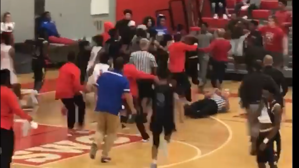 A frame taken from video footage of the brawl between Alton and Riverview Gardens shows a scrum of players moving toward the bleachers as a referee is knocked down. The fight resulted in a double forfeit and a cancellation of the Alton Tip-Off Classic’s remaining games.