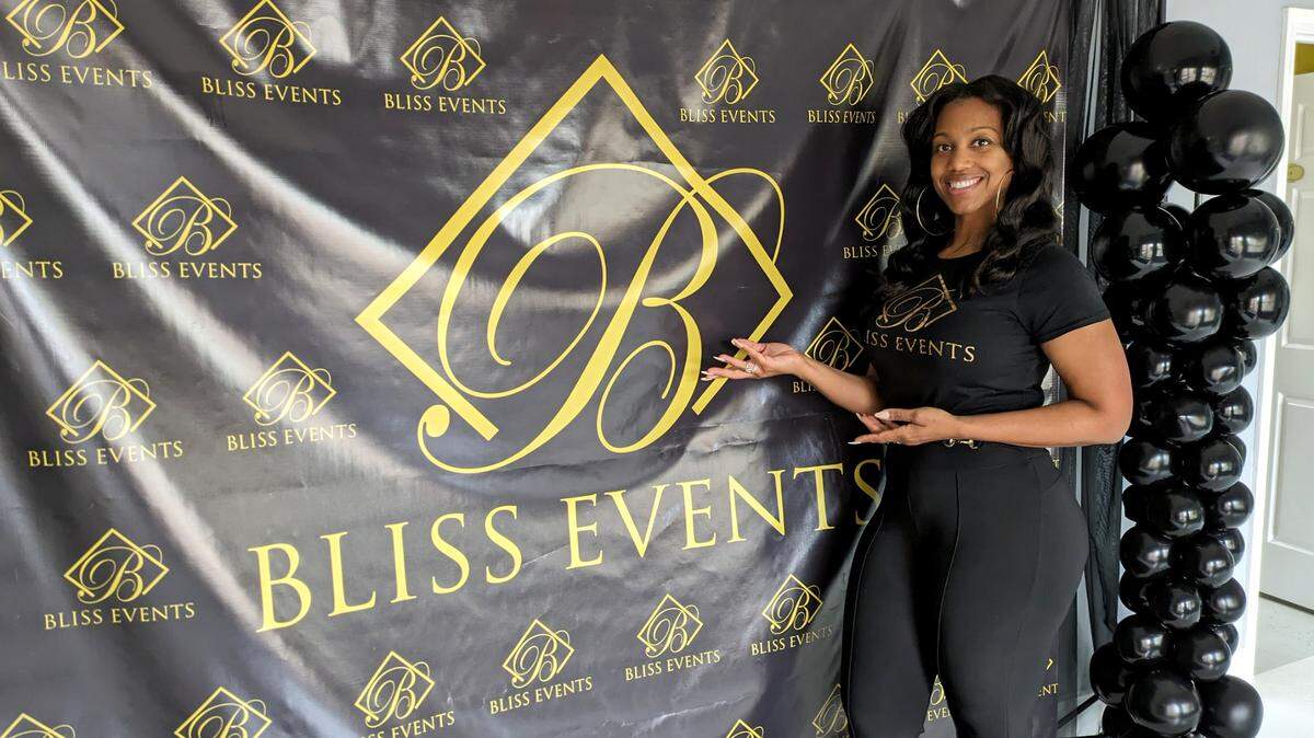 Bliss Events owner M.J. Yancey poses in a spot where guests can take photos during their events.