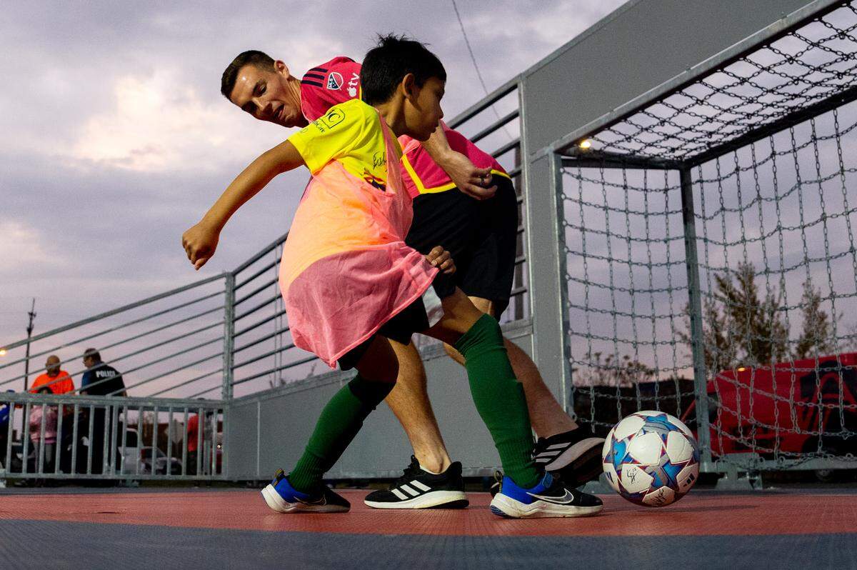 St. Louis City SC defender Kyle Hiebert (22) attempts to keep the ball from Noah Strehl, 8, of Highland, on Thursday, Oct. 26, 2023, during the dedication of a community mini pitch at Granby Park in Fairmont City.