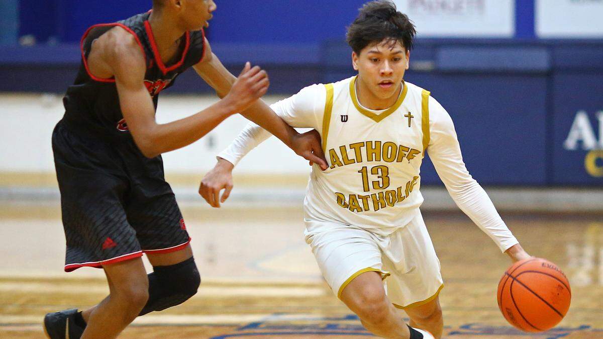 Althoff’s Anthony Reed drives against Granite City’s Zidane Moore during Wednesday game at Althoff High School.
