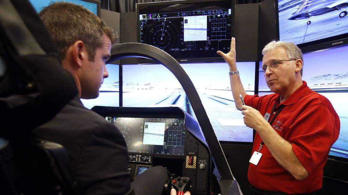 Lockheed Martin systems engineer Dennis Littrell (right) explains the instrumentation of the F-35 fighter jet simulator to U.S. Rep. Adam Kinzinger Monday, July 1, 2013, at UTC Aerospace Systems in Rockford.