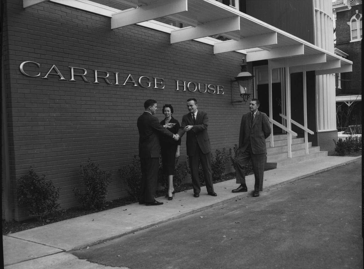 Vic Morrow, general contractor for the Carriage House Restaurant, hands the keys to Robert Kelce, president of the new establishment, on Nov. 23, 1959. Diane Kelce and Charles E. King, architect, are witnesses.