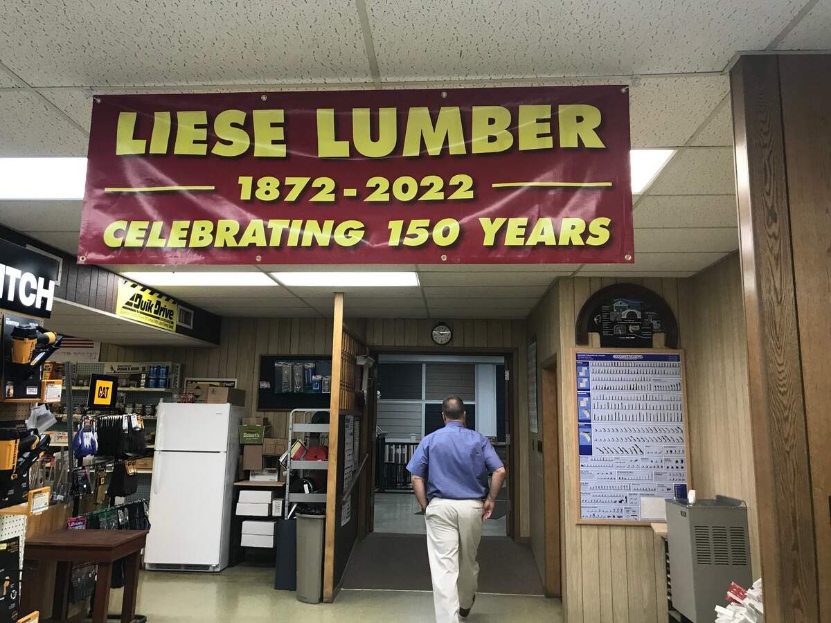Mike Lippert, president of Liese Lumber Co. in Belleville, walks under a 150th anniversary banner. He’s the fourth generation in his family to lead the company since his great-great-grandfather, Oscar, took over in the 1920s.