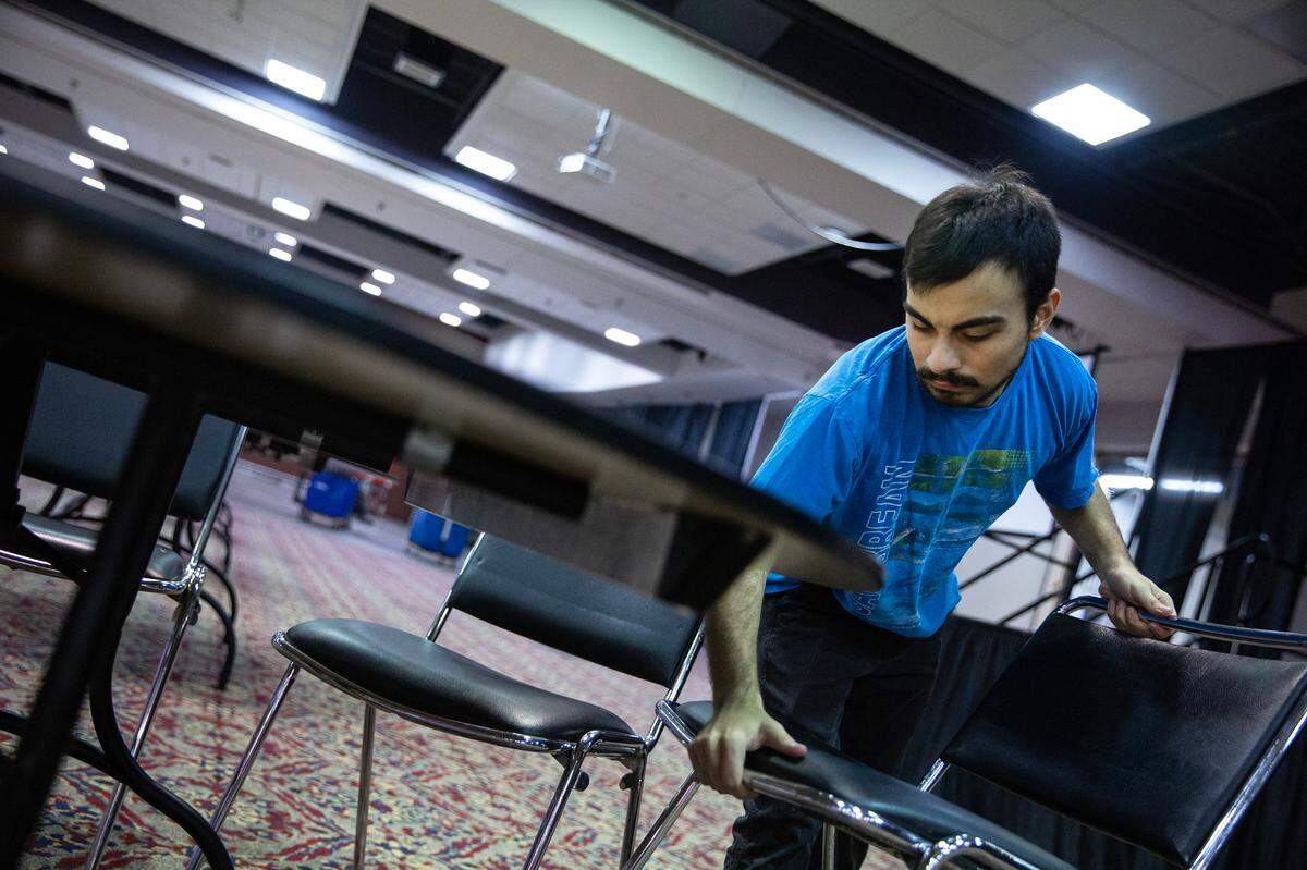 Joseph Sanchez, 18, sets up chairs in preparation for an upcoming event on Tuesday, Nov. 14, 2023, at the Gateway Convention Center in Collinsville, Ill. Sanchez is a senior at Collinsville High School and a part of an apprenticeship program for students with disabilities.