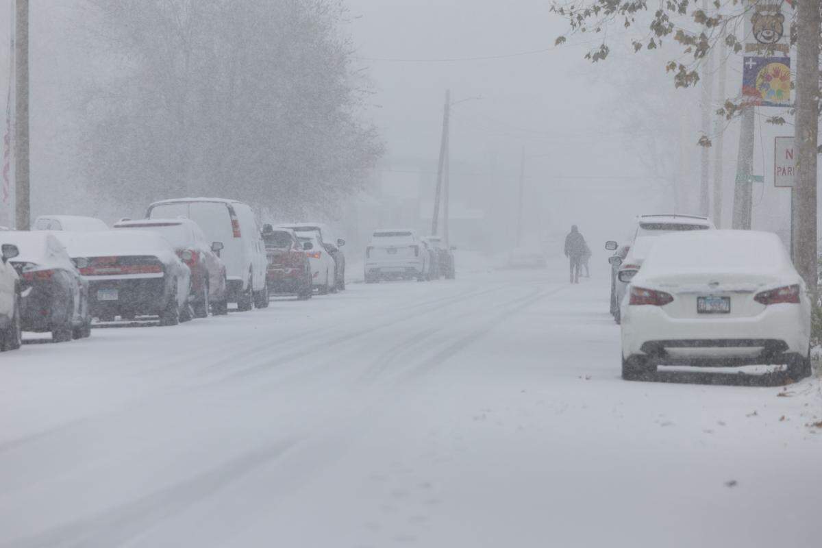 Two people make their way in the snow along 10th Street in East St. Louis on Monday.