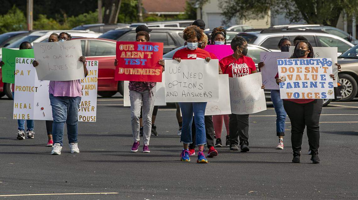 Parents and family members of students in East St. Louis School District 189 march to the administration offices of the district. The group wantss options for remote student learning and details about infection rates in schools and classrooms to better protect family and their children.