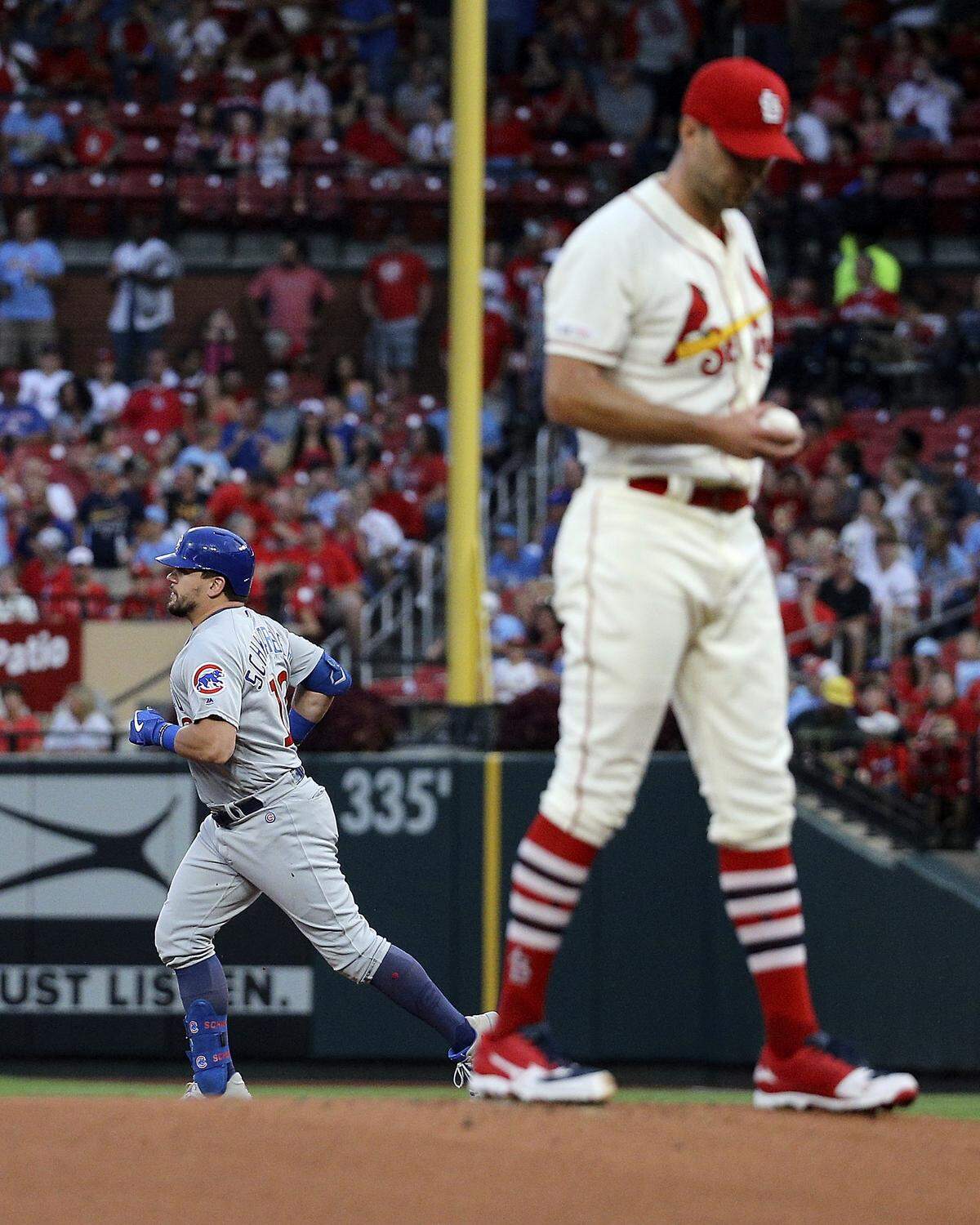 Chicago Cubs’ Kyle Schwarber, back left, runs the bases after hitting a solo home run off St. Louis Cardinals starting pitcher Adam Wainwright, right, during the first inning of a baseball game Saturday, Sept. 28, 2019, in St. Louis. (AP Photo/Scott Kane)