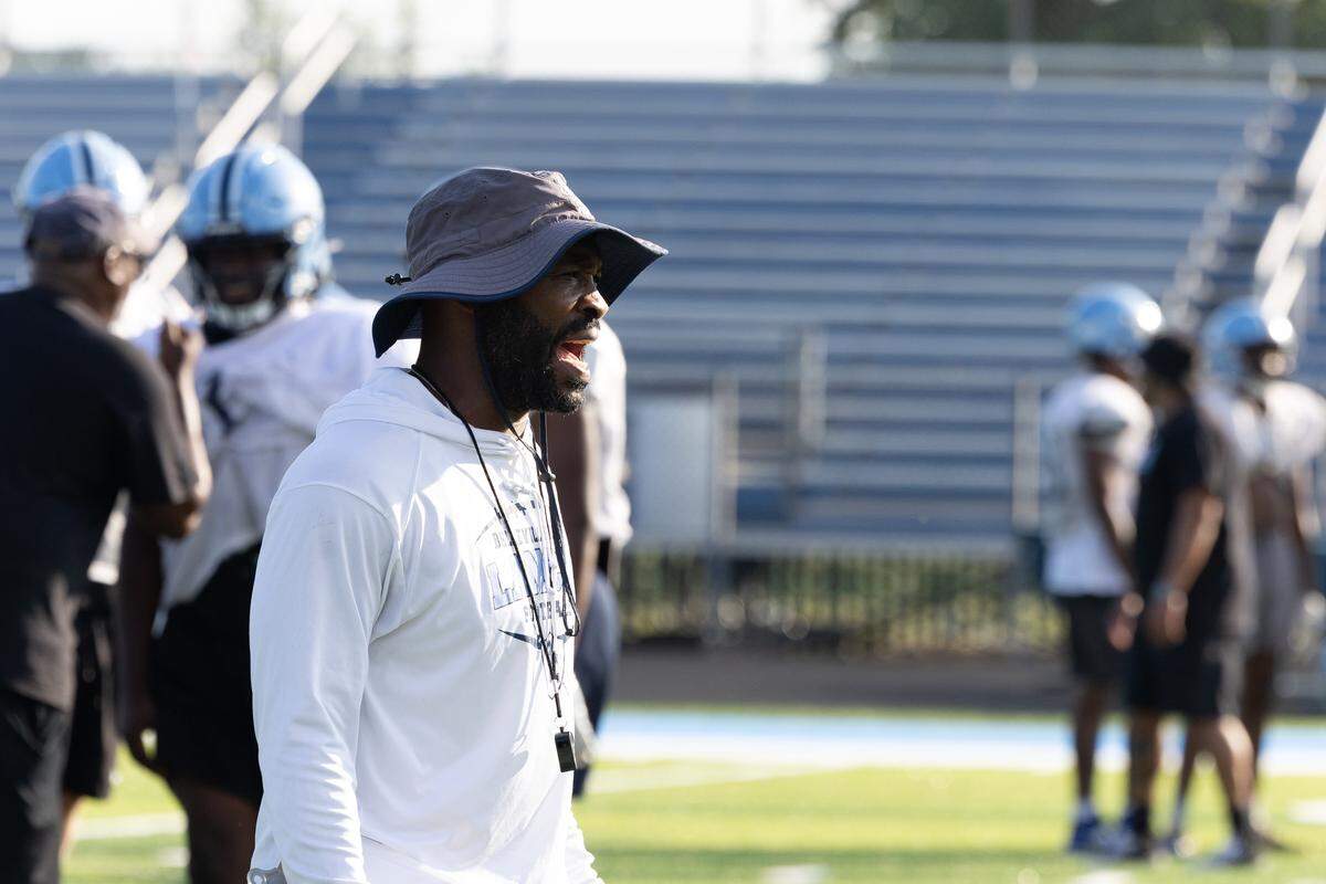 Belleville East football coach Michael Harrison calls for players to “know their jobs” during drills.