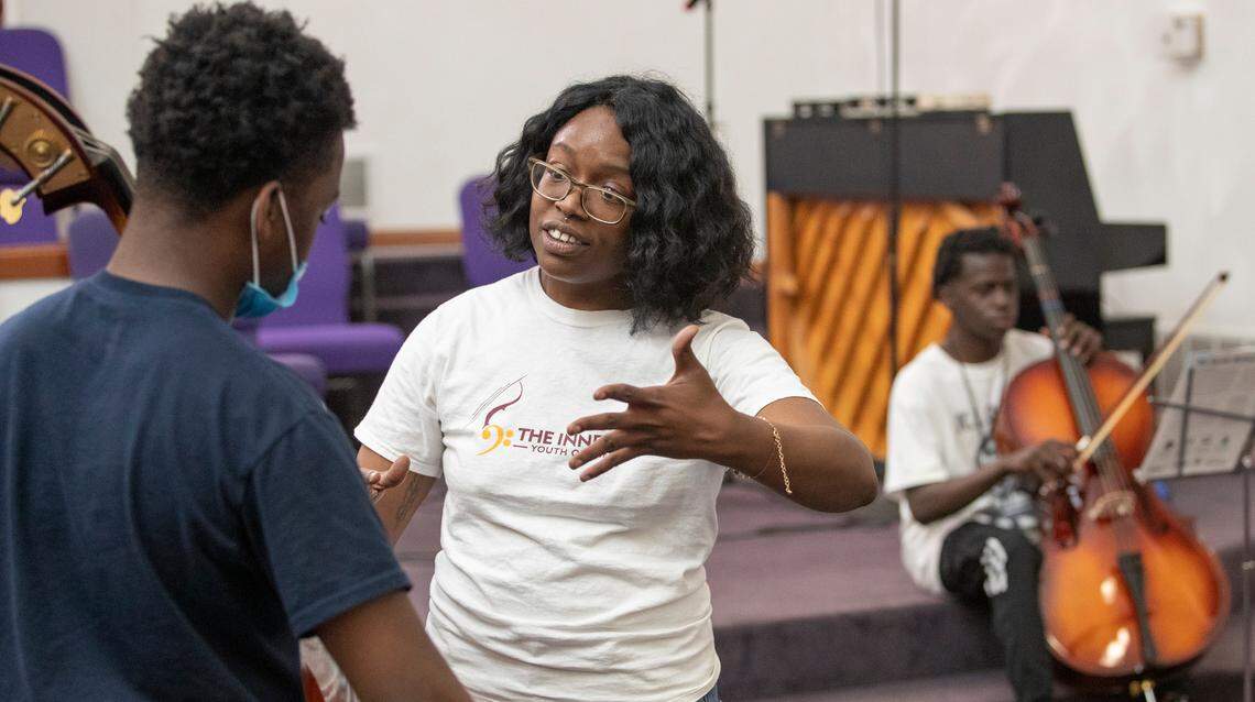 Rosalind Denise Rogers works with Carl Hill and Williams Austin during a music lesson.