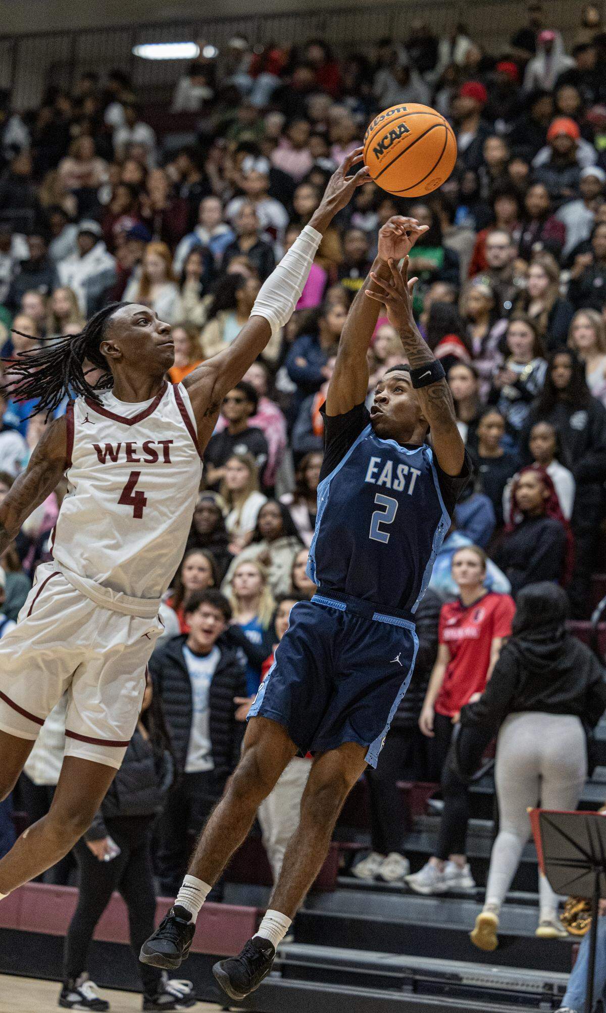 Belleville East senior Troy Alexander attempts a shot under pressure from West’s TJ Cason IV Friday.