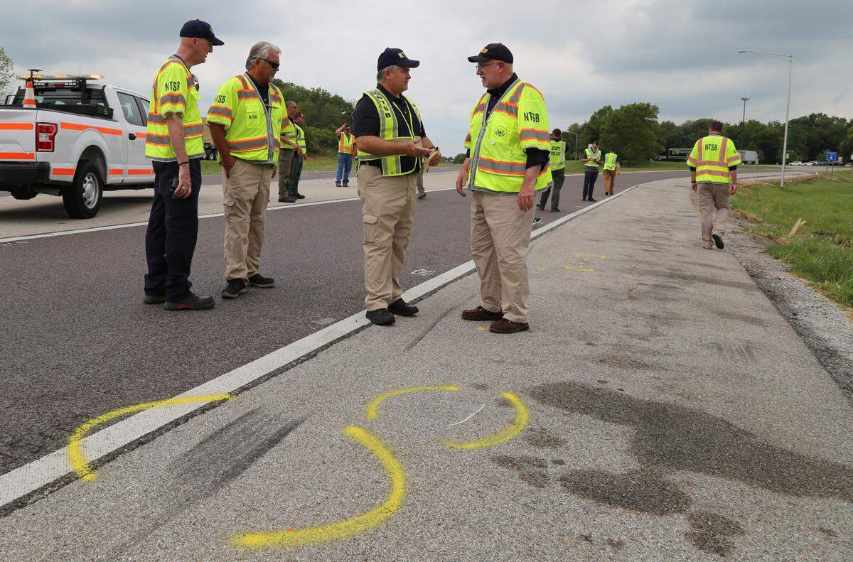 In this July 13, 2023 photo, National Transportation Safety Board investigator-in-charge Steve Prouty (center) briefs NTSB member Tom Chapman adjacent to tire friction marks at the site of the July 12 crash on I-70 near Highland, Illinois.
