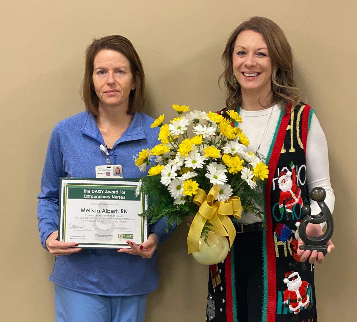 Teresa Cornelius, right, chief nursing officer, presents Melissa Albert, left, RN and manager of the wound care center, with The DAISY Award for Extraordinary Nurses at HSHS St. Joseph’s Hospital Highland. (Masks were removed temporarily for photo.)